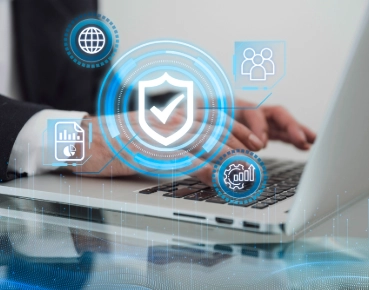 Businessman working on laptop with digital security and analytics icons overlay.